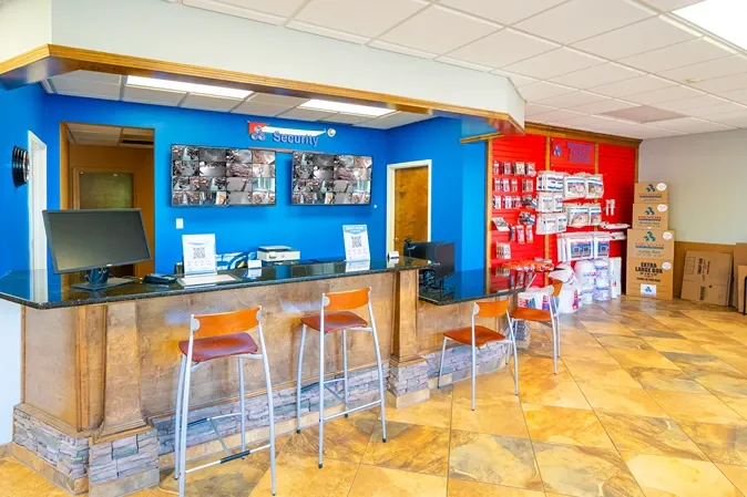Self storage office with customer service counter and security monitoring screens